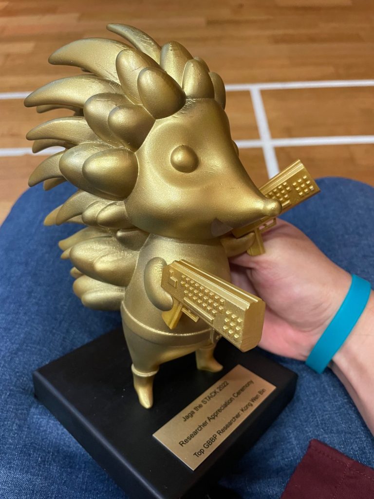 The Top GBBP Researcher award is a very cute looking trophy with a 3D statue of Jaga (Hedgehog), the Singapore Government's mascot for cybersecurity, holding a keyboard on each hands [45-Degree-View]